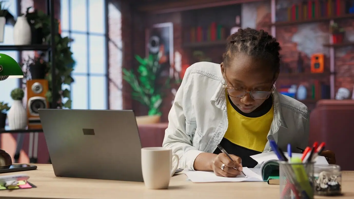 Бухгалтер, работающий удаленно из дома, проверяет счета и вводит данные на ноутбуке.